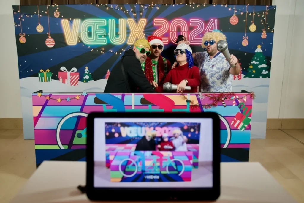 Un groupe de collaborateurs prennent la pose sur l’animation Vélo Photo pour un souvenir pendant un team building green.