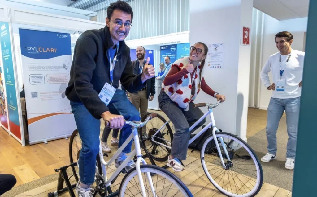 2 personnes s'amusent à pédaler sur des vélos générateurs d'électricité sur un salon