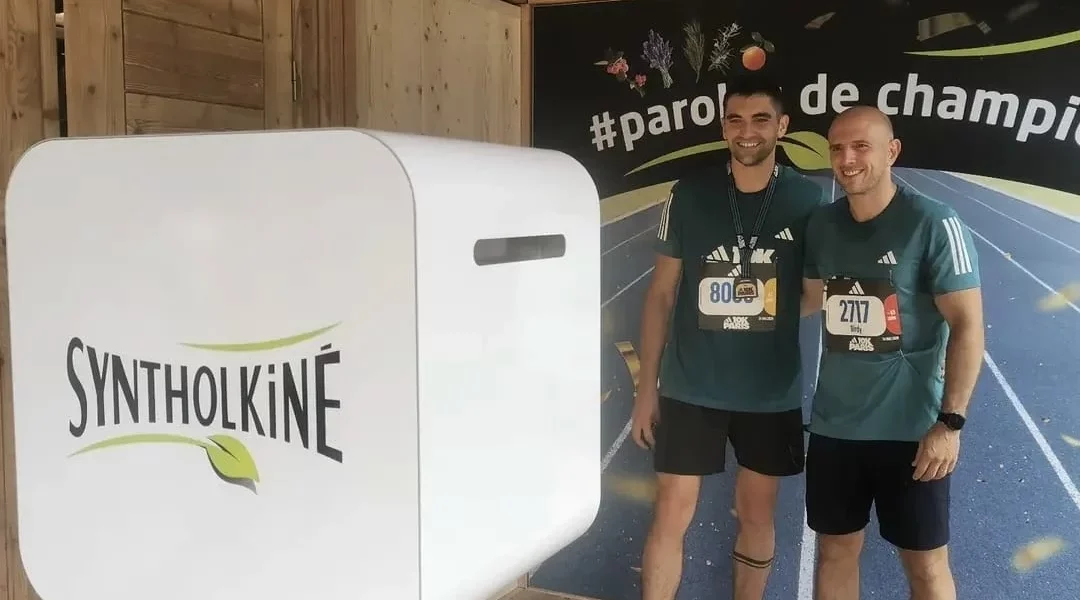 2 personnes prennent la pose devant un photobooth interactif