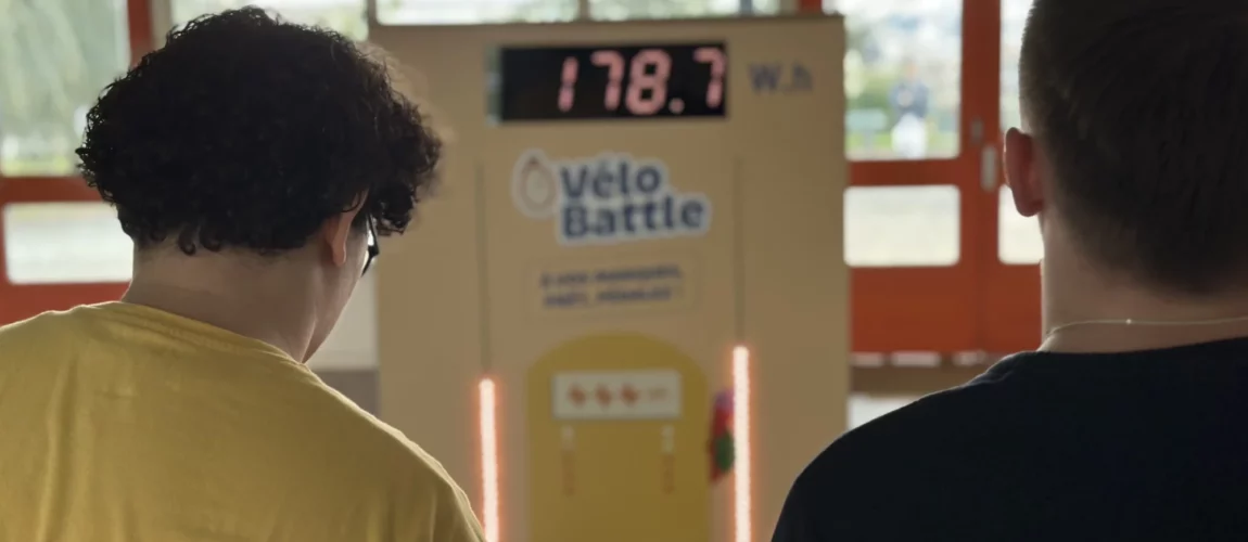2 jeunes étudiants regardent le nombre de watt.heures qu'ils ont produit sur des vélos générateur d'électricité