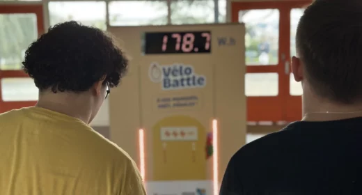 2 jeunes étudiants regardent le nombre de watt.heures qu'ils ont produit sur des vélos générateur d'électricité
