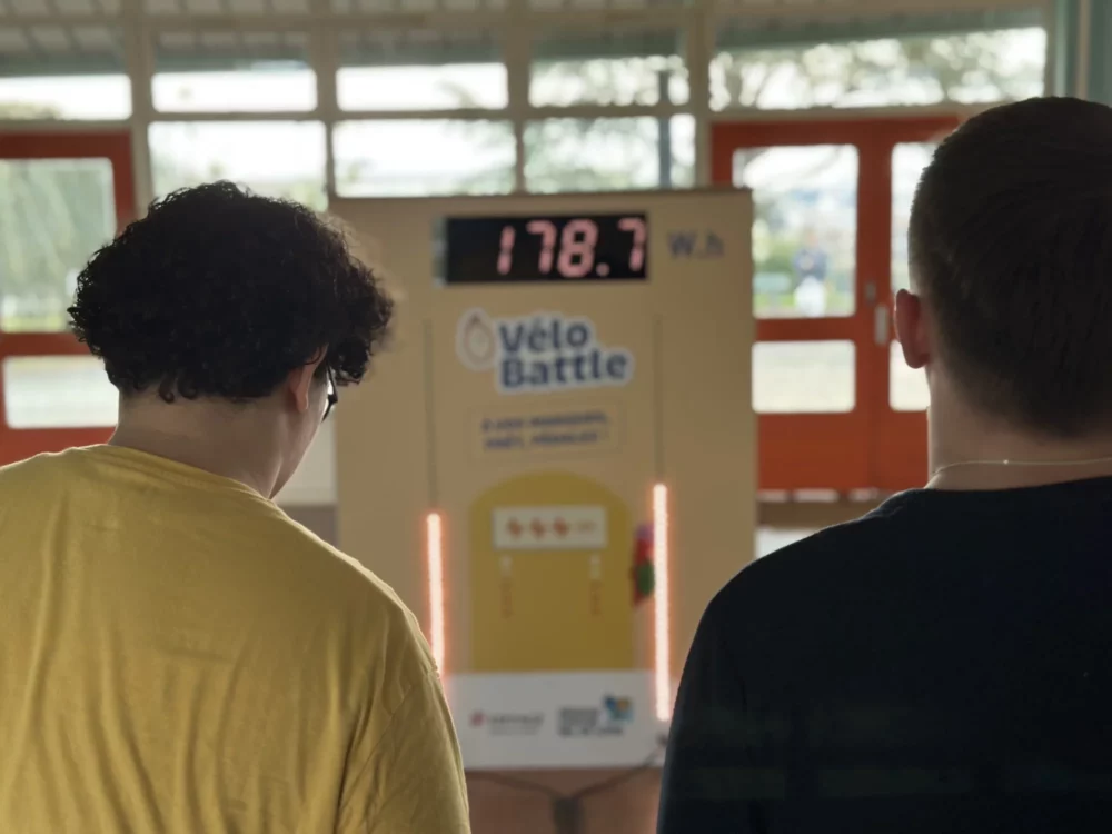 2 jeunes étudiants regardent le nombre de watt.heures qu'ils ont produit sur des vélos générateur d'électricité