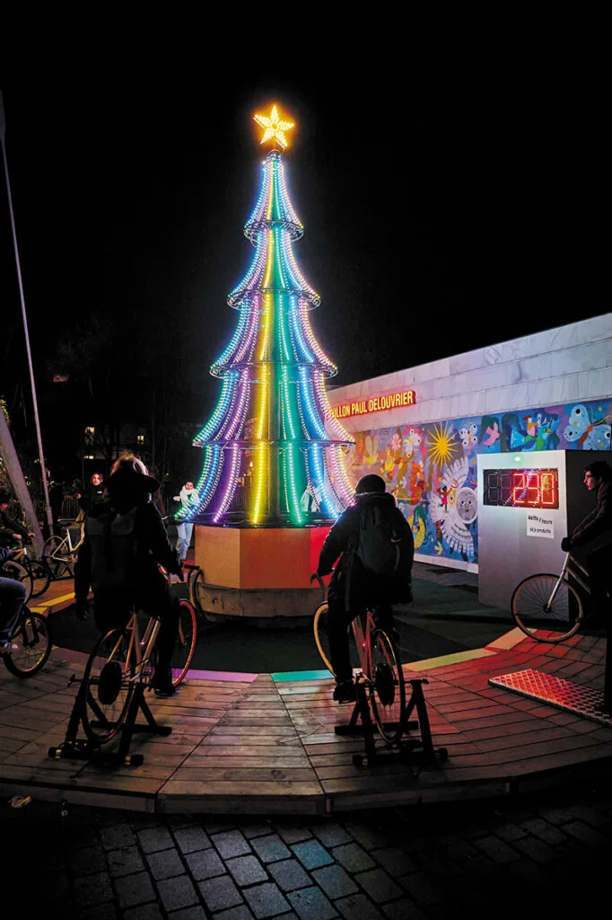 Illumination d’un grand sapin à l’aide de vélos générateurs, à l’occasion d’une animation de Noël en entreprise.
