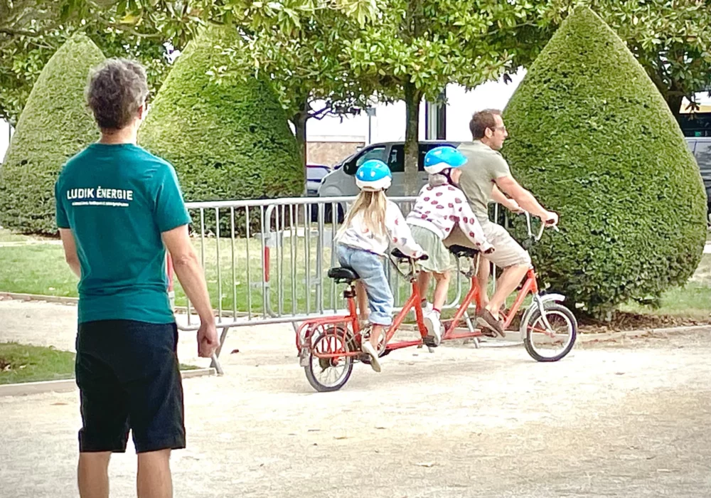 Un animateur Ludik Energie regarde une famille s'amuser sur la place publique