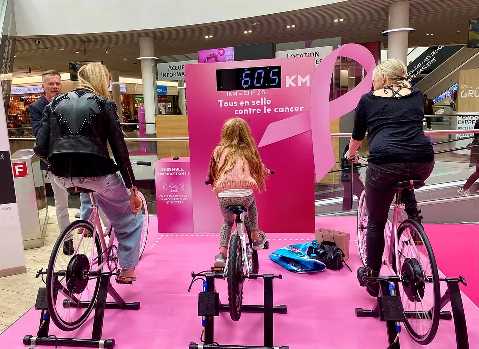 Des visiteurs d'un centre commercial pédalent pour cumuler des kilomètres à l'occasion d'octobre rose