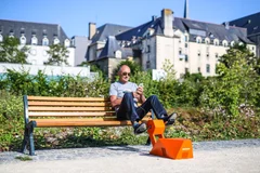 Un passant recharge son téléphone en pédalant dans un parc