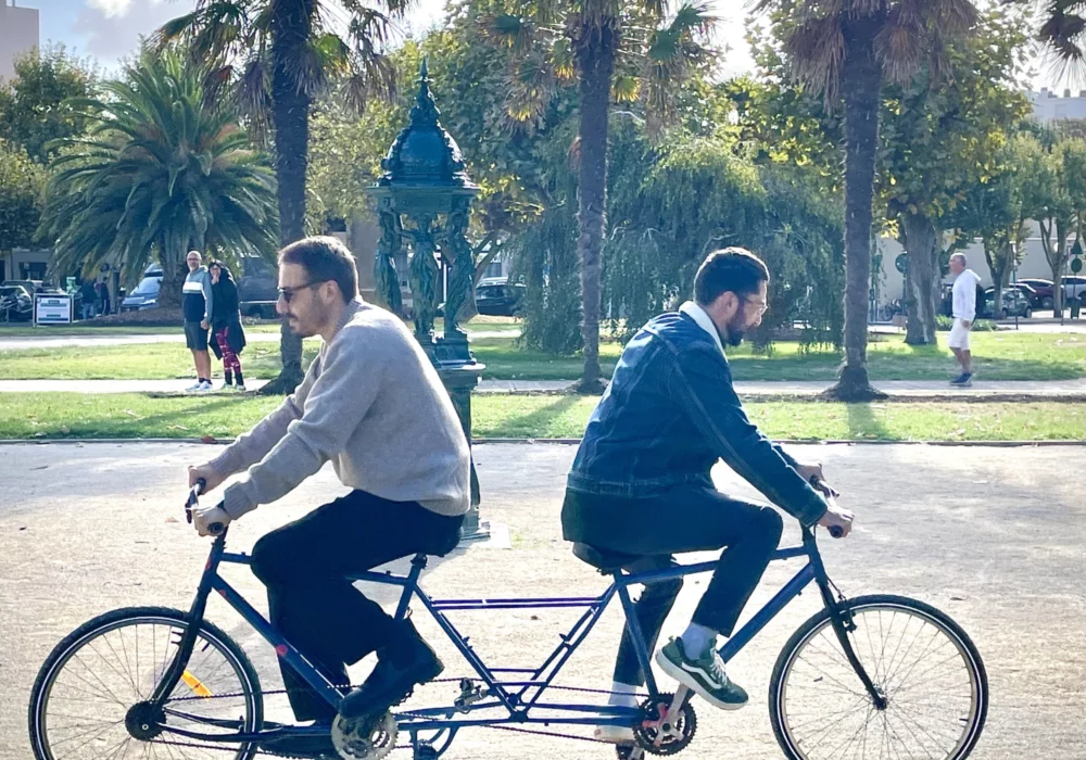 Deux adultes sont dos à dos sur un seul et même vélo surprenant