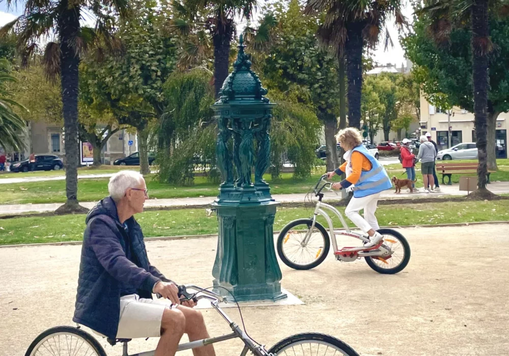 Deux adultes s'approprient les vélos insolites sur la place publique